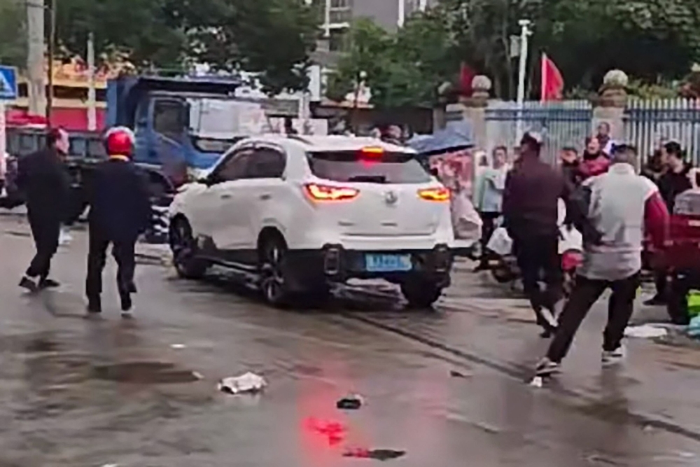 This frame grab taken from video footage circulating on Chinese social media on November 19, 2024, shows the scene where a car crashed outside the Yong'an primary school in Changde, central China's Hunan province. (Photo by social media / AFP) 