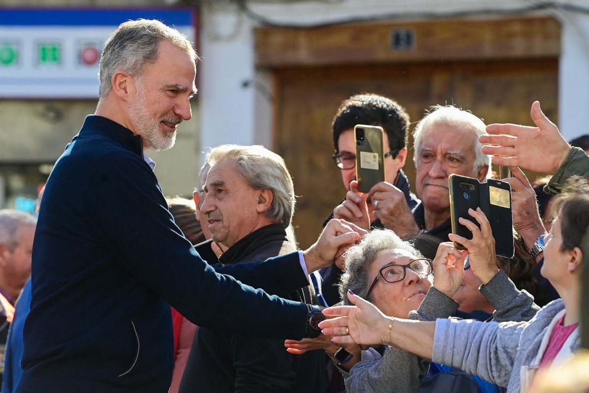 Spain's King Felipe VI greets residents during a visit to the flood damaged town of Chiva, in the region of Valencia, eastern Spain, in the aftermath of catastrophic deadly floods, on November 19, 2024. Photo by JOSE JORDAN / AFP