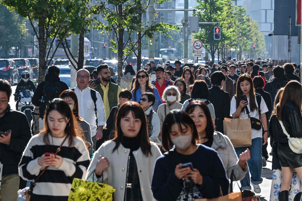 Pedestrians walk down the high-street shopping area of the Ginza district in central Tokyo on November 22, 2024. Photo by Richard A. Brooks / AFP