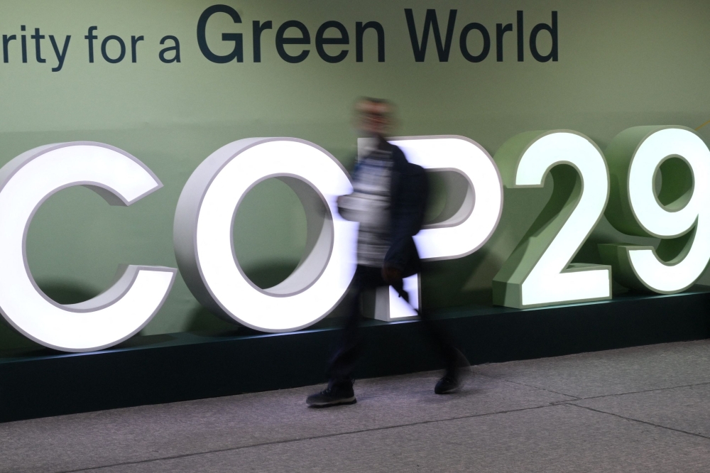 Attendees walk past the COP29 logo during the United Nations Climate Change Conference (Cop29) in Baku, Azerbaijan, on November 21, 2024. (Photo by STRINGER / AFP)

