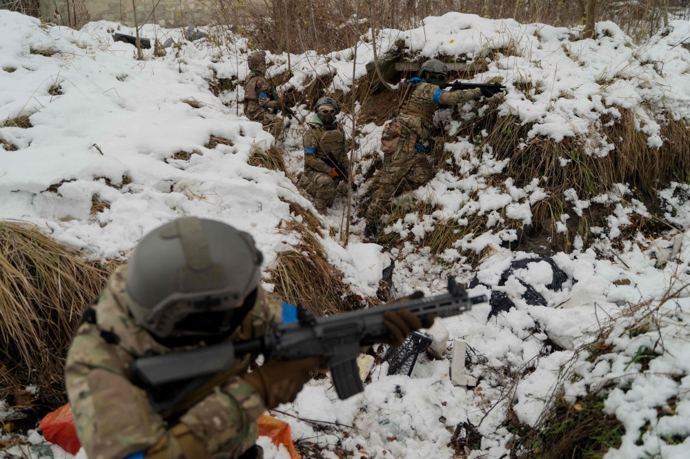 Civilians wearing military uniforms take part in a military training organized by Ukrainian soldiers of The Third Separate Assault Brigade in Kyiv, on November 23, 2024. (Photo by Tetiana Dzhafarova / AFP)