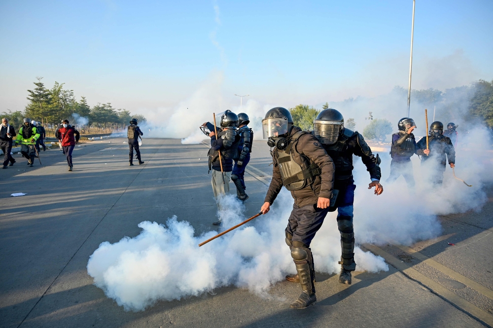 Policemen fire tear gas shells to disperse supporters of Pakistan Tehreek-e-Insaf (PTI) party during a protest to demand the release of former prime minister Imran Khan, in Islamabad on November 26, 2024. (Photo by Aamir Qureshi / AFP)