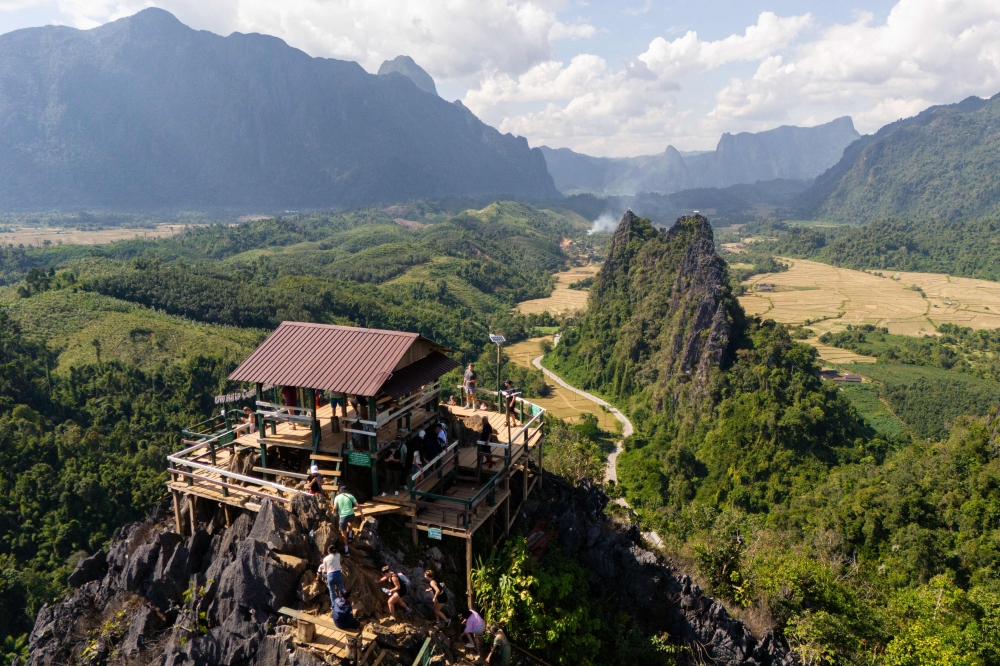 Tourists look at the surroundings from Namxay Viewpoint in Vang Vieng on November 24, 2024. Photo by AFP