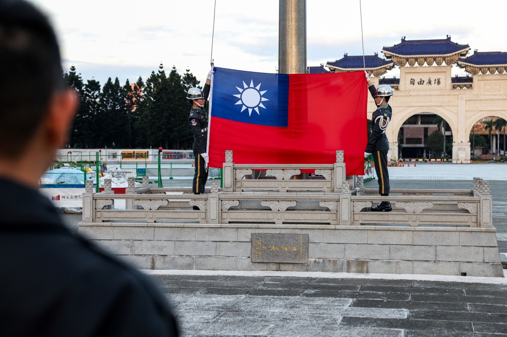 Guards raise Taiwan's national flag on the Democracy Boulevard at the Chiang Kai-shek Memorial Hall in Taipei on November 29, 2024. (Photo by I-Hwa Cheng / AFP)