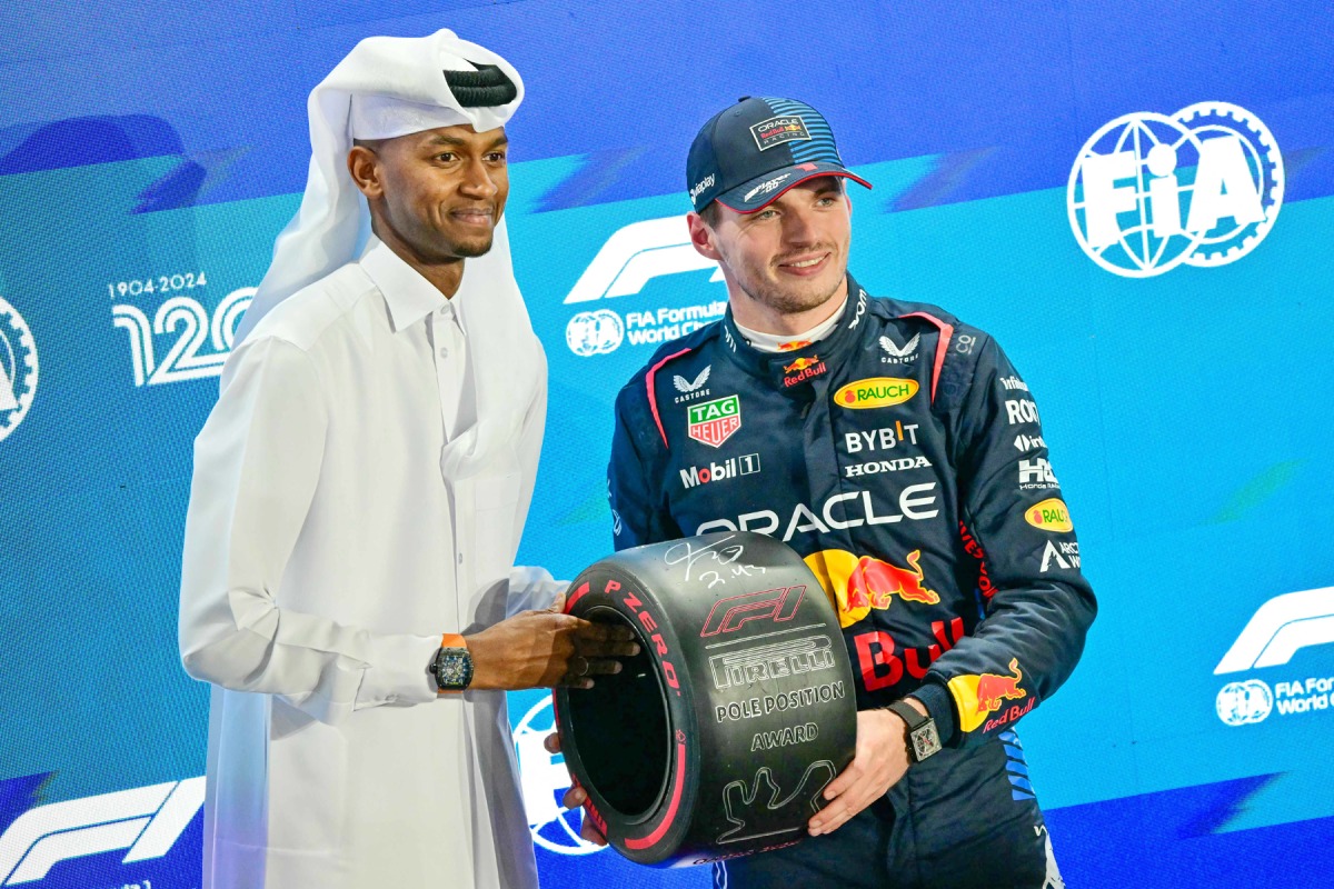 Red Bull Racing’s Dutch driver Max Verstappen (right) receives the pole position trophy from Qatar’s track and field athlete Mutaz Essa Barshim yesterday. AFP