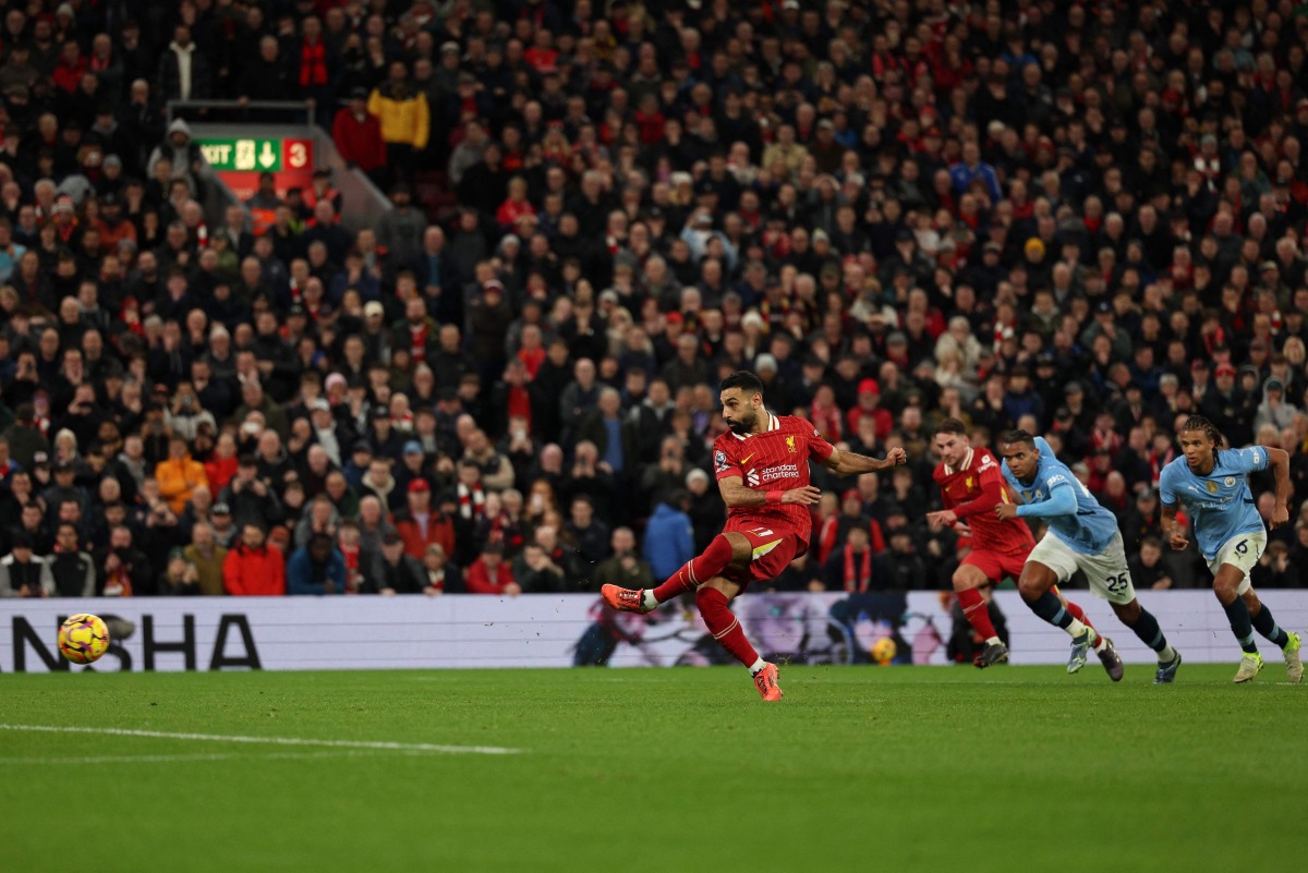 Liverpool's Egyptian striker #11 Mohamed Salah shoots from the penalty spot to score the team's second goal during the English Premier League football match between Liverpool and Manchester City at Anfield in Liverpool, north west England on December 1, 2024. (Photo by Adrian Dennis / AFP)