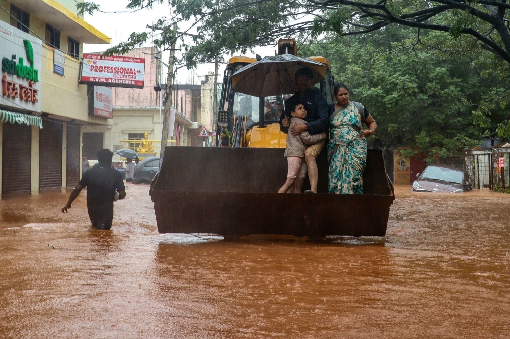 A family is being rescued from a cyclone-affected area after heavy rainfall in Puducherry on December 1, 2024. (Photo by AFP)
 