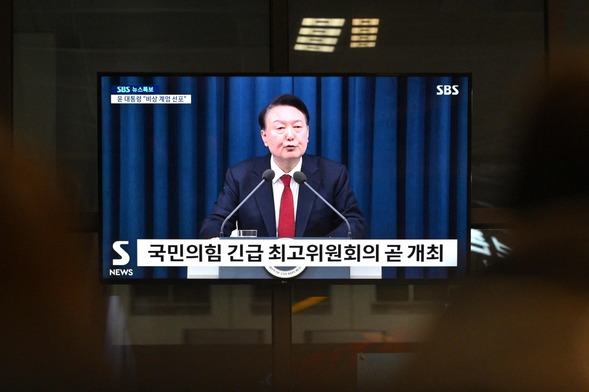 South Korea's President Yoon Suk Yeol is seen speaking on a television in a train station in Seoul late on December 3, 2024, after he declared emergency martial law, saying the step was necessary to protect the country from 