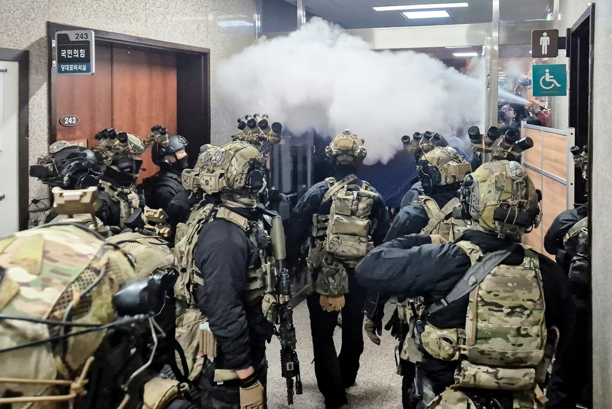 Soldiers try to enter the main hall of the National Assembly on December 3, 2024, after South Korea President Yoon Suk Yeol declared martial law. South Korea's President Yoon Suk Yeol on December 3 declared martial law, accusing the opposition of being 