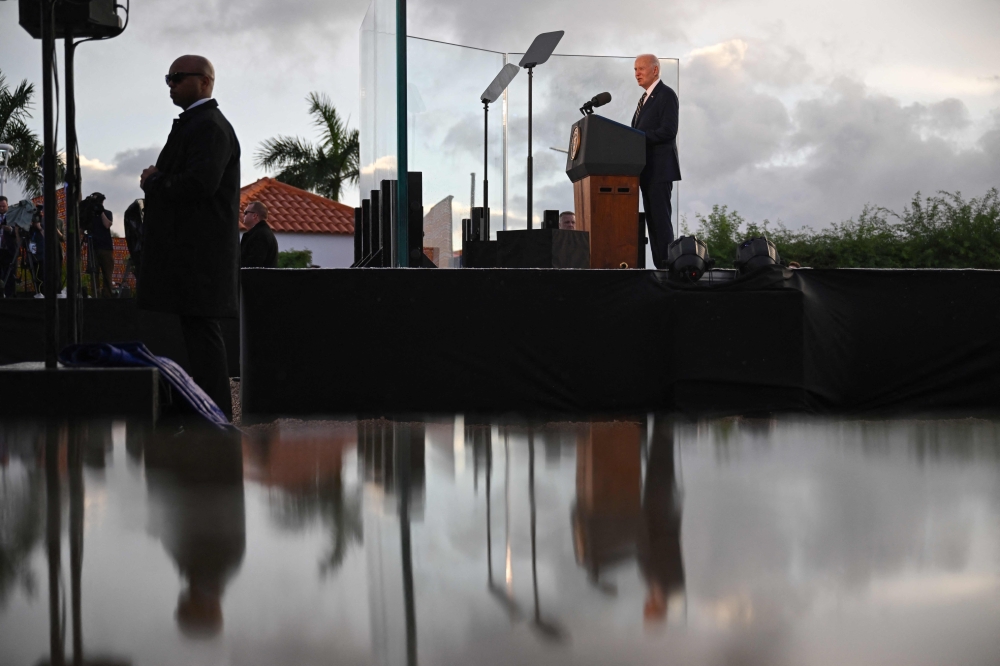 US President Joe Biden speaks as members of his security detail look on while visiting the National Slavery Museum in Morro da Cruz, near Luanda, on December 3, 2024. (Photo by Andrew Caballero-Reynolds / AFP)