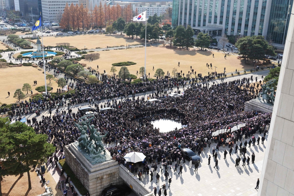 Opposition party members and members of civic groups hold a rally to ask for the resignation of South Korea President Yoon Seoul Yeol on the steps in front of the National Assembly building in Seoul on December 4, 2024. (Photo by Yonhap / AFP) 