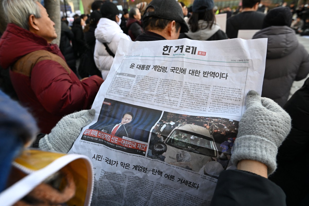 Photo used for representational purposes. A man reads an extra edition newspaper in downtown Seoul on December 4, 2024, after martial law was lifted. Photo by Jung Yeon-je / AFP.