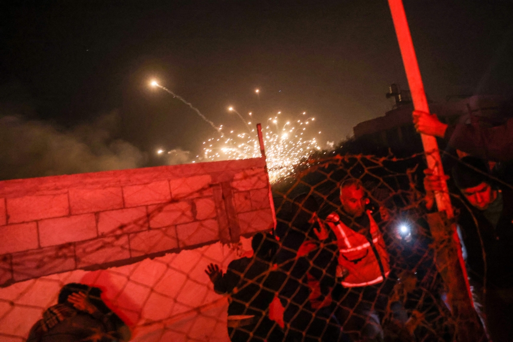 People run for cover as an explosion from an Israeli strike occurs near a makeshift camp for displaced Palestinians, in Mawasi Khan Yunis in the southern Gaza Strip on December 4, 2024. (Photo by Bashar Taleb / AFP)