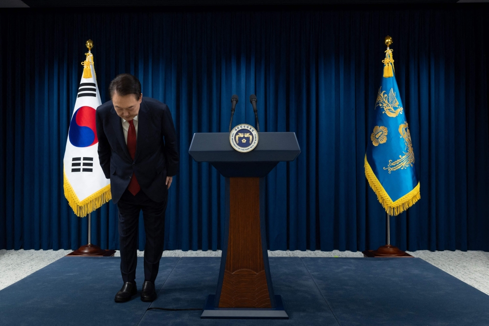 This handout photo taken and released on December 7, 2024 by the South Korean Presidential Office shows South Korea's President Yoon Suk Yeol bowing after the end of his address at the Presidential Office in Seoul. (Photo by Handout / South Korean Presidential Office / AFP) 