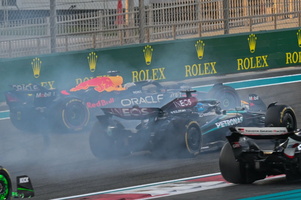 Red Bull Racing's Dutch driver Max Verstappen (left) drives on after a collision with McLaren's Australian driver Oscar Piastri during the Abu Dhabi Formula One Grand Prix at the Yas Marina Circuit in Abu Dhabi on December 8, 2024. (Photo by Andrej Isakovic / AFP)