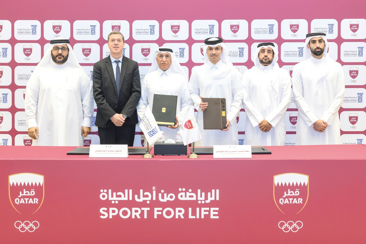 QOC Secretary General Jassim bin Rashid Al Buenain and President of University of Doha for Science and Technology Dr. Salem bin Nasser Al Naemi pose for a group picture along with other officials.  