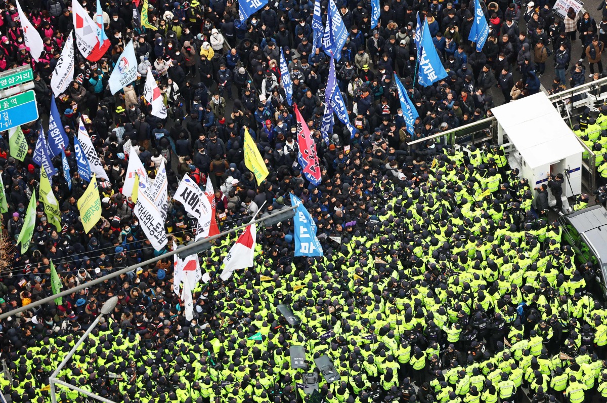 Police (bottom) attempt to block protesters calling for the impeachment of South Korea President Yoon Suk Yeol and the dissolution of the People's Power Party from marching towards the presidential office in Seoul on December 12, 2024. Photo by YONHAP / AFP