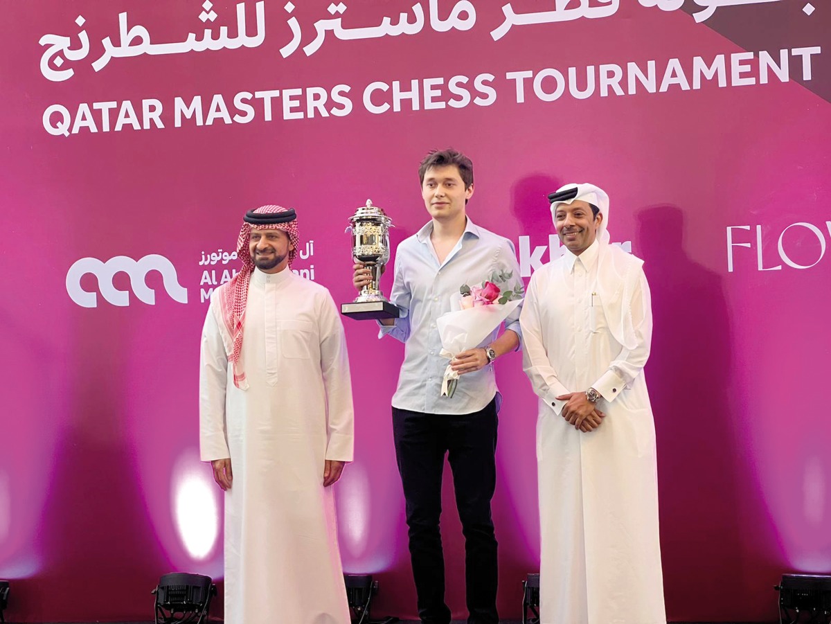 Qatar Masters Open 2024 champion Andrey Esipenko poses with the winner's trophy  next to Qatar Chess Association President Mohammed Al Mudahka (right).