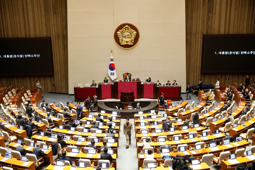 South Korean lawmakers cast their votes during a plenary session for the impeachment vote of President Yoon Suk Yeol at the National Assembly in Seoul on December 14, 2024. (Photo by Woohae Cho / Pool / AFP)