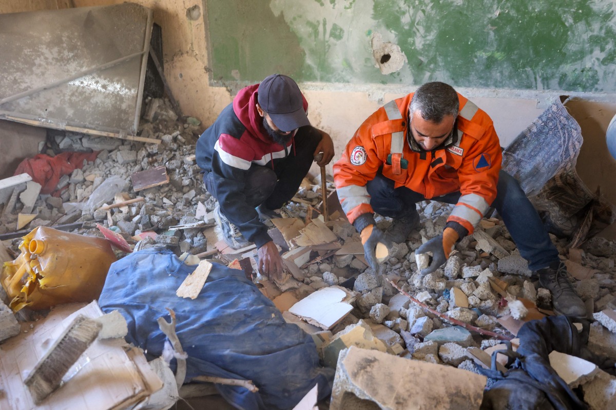 Rescuers look for survivors following an Israeli strike on the UNWRA Al-Majda Wasila Governmental School housing displaced Palestinians, on al-Jalaa Street in Gaza City on December 14, 2024. (Photo by Omar AL-QATTAA / AFP)
