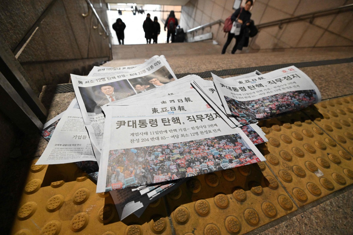 Extra edition newspapers are displayed at a subway station gate in downtown Seoul on December 14, 2024, after the impeachment motion against South Korean President Yoon Suk Yeol was passed. Photo by Jung Yeon-je / AFP