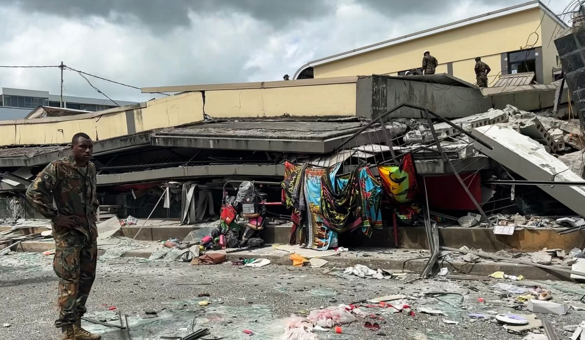 This screengrab taken from handout video footage posted on the Facebook account of Michael Thompson on December 17, 2024 shows a member of security inspecting a collapsed building in Vanuatu's capital Port Vila after a powerful earthquake hit the Pacific island. Photo by MICHAEL THOMPSON / Facebook account of Michael Thompson / AFP