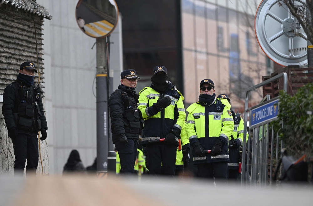 Police officers stand guard as protesters hold a demonstration calling for the ouster of South Korea President Yoon Suk Yeol near the presidential residence in Seoul on December 17, 2024. (Photo by Jung Yeon-je / AFP)