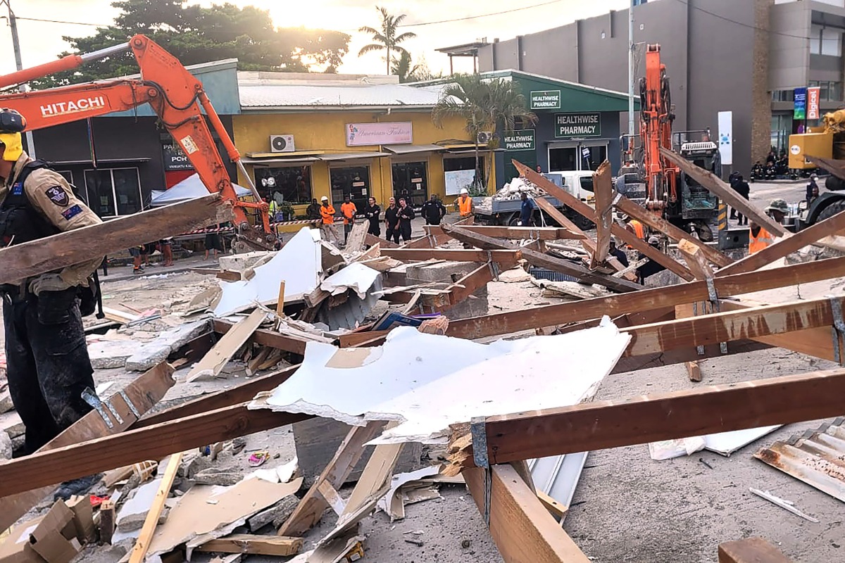 This handout photo taken and released on December 20, 2024 by the Australian Department of Foreign Affairs and Trade (DFAT) shows Australian rescue workers at the site of a collapsed building after an earthquake struck Port Vila, the capital city of Vanuatu. Photo by Handout / AUSTRALIAN DEPARTMENT OF FOREIGN AFFAIRS AND TRADE / AFP