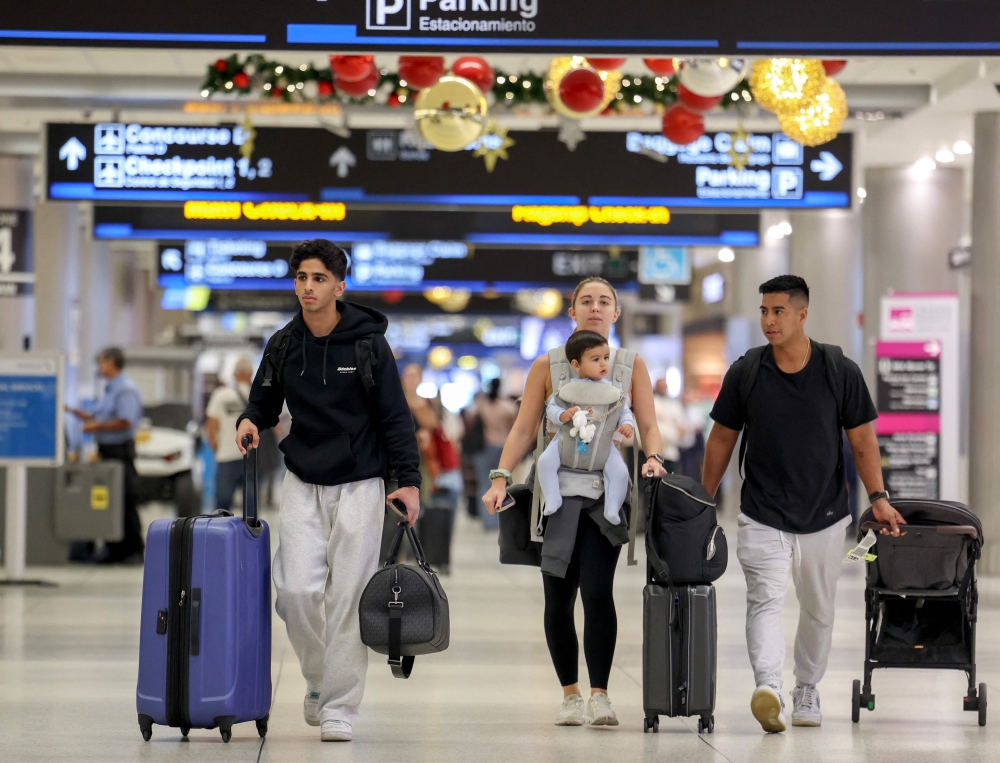 Travelers pass through the Miami International Airport as some of the year's busiest travel days occur during the holiday season on December 20, 2024 in Miami, Florida. (Photo by Joe Raedle/Getty Images/AFP)