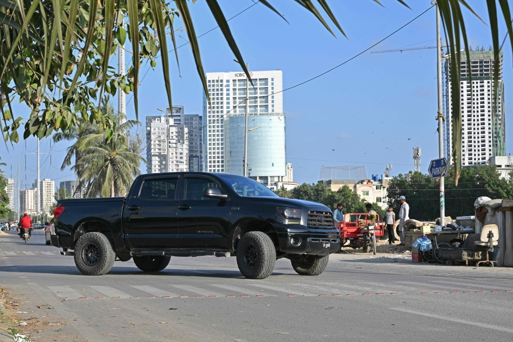 This photograph taken on November 12, 2024 shows car enthusiast Zohaib Khan driving a Toyota Tundra pick-up truck locally known as 'Dala', along a street in Karachi. (Photo by Asif Hassan / AFP) 