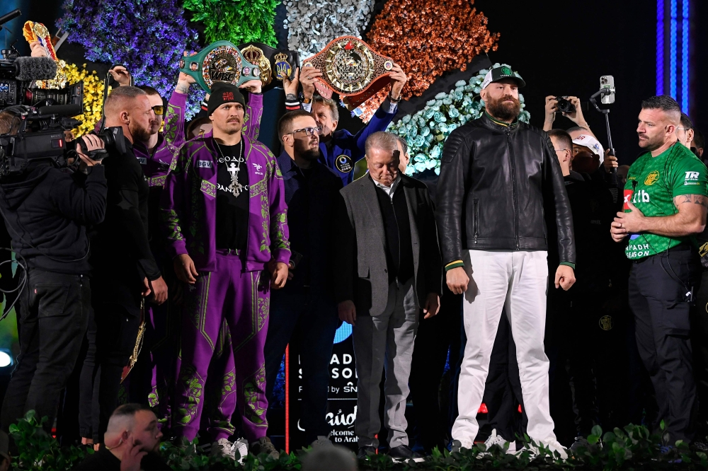 Ukraine's Oleksandr Usyk (C-L) and Britain's Tyson Fury (C-R) stand on stage during the official weigh-in on the eve of their undisputed heavyweight world championship rematch in Riyadh on December 20, 2024. (Photo by AFP)
 