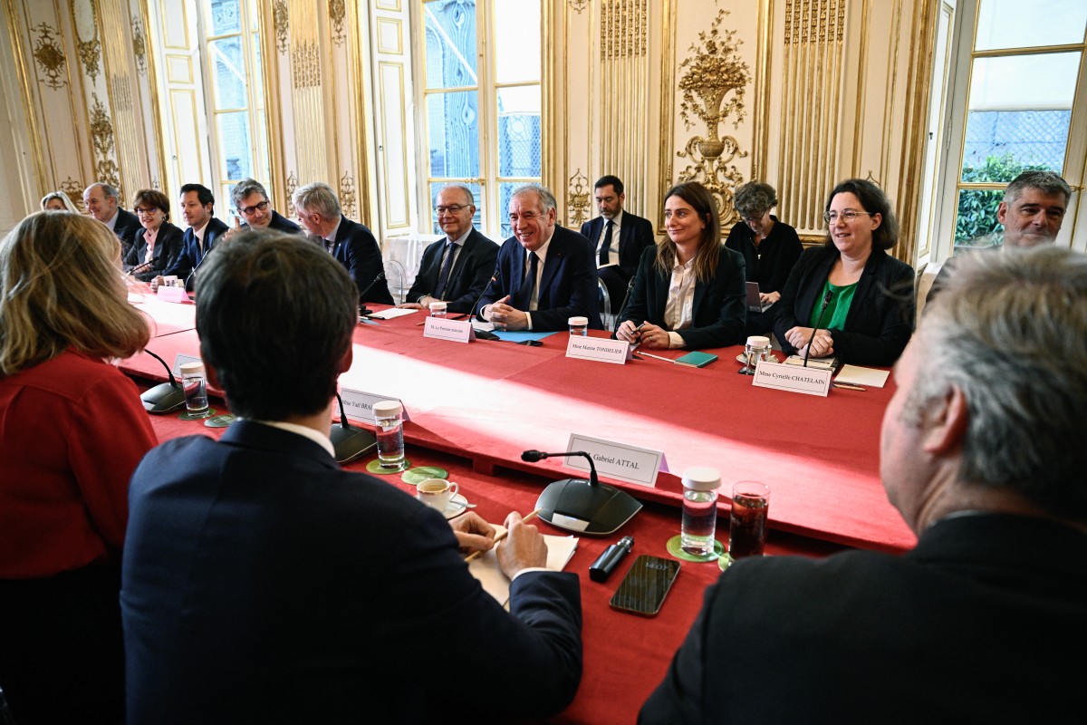 France's Prime Minister Francois Bayrou (C) attends a meeting with the President of the French National Assembly Yael Braun-Pivet (L), Senate President and party leaders excluding La France Insoumise (LFI) nor Rassemblement National party (RN), to finalise his government at the Hotel Matignon in Paris, on December 19, 2024. Photo by JULIEN DE ROSA / POOL / AFP.