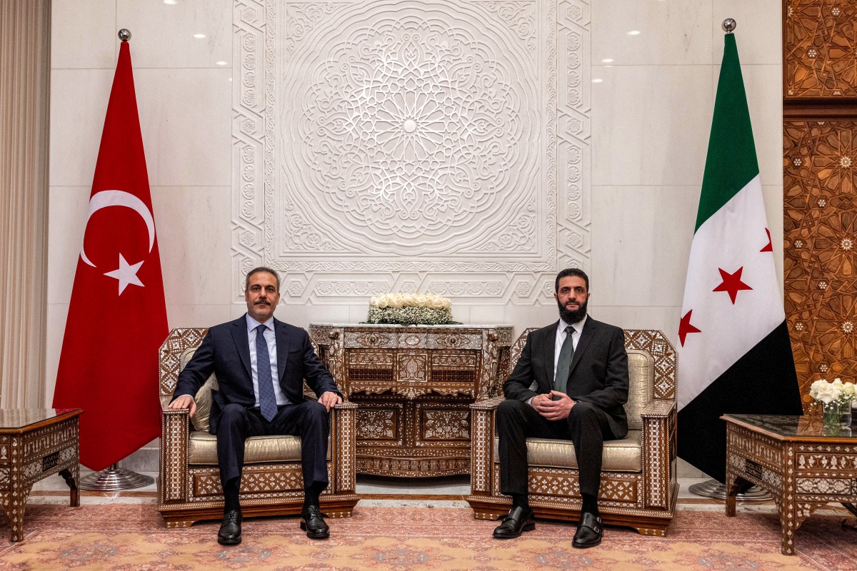 This handout picture released by the Turkish Foreign Ministry press service shows Turkey's Foreign Minister Hakan Fidan (L) being received by Hayat Tahrir al-Sham (HTS) leader Ahmed al-Sharaa, in Damascus on December 22, 2024. Photo by TURKISH FOREIGN MINISTRY / AFP.