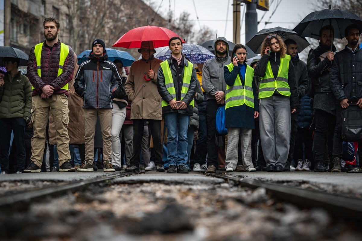 Students, pupils and citizens block a street in front of the Faculty of Law in Belgrade on December 20, 2024, standing in silence to honour the 15 victims of the tragedy that occurred at the railway station in Novi Sad in November 2024. Photo by Andrej ISAKOVIC / AFP