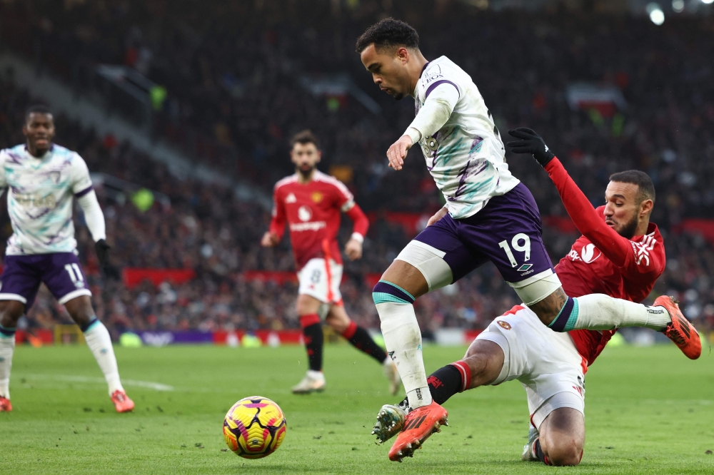 Manchester United's Moroccan defender #03 Noussair Mazraoui (right) fouls Bournemouth's Dutch striker #19 Justin Kluivert (centre) for a penalty during the English Premier League football match between Manchester United and Bournemouth at Old Trafford in Manchester, north west England, on December 22, 2024. (Photo by Darren Staples / AFP)