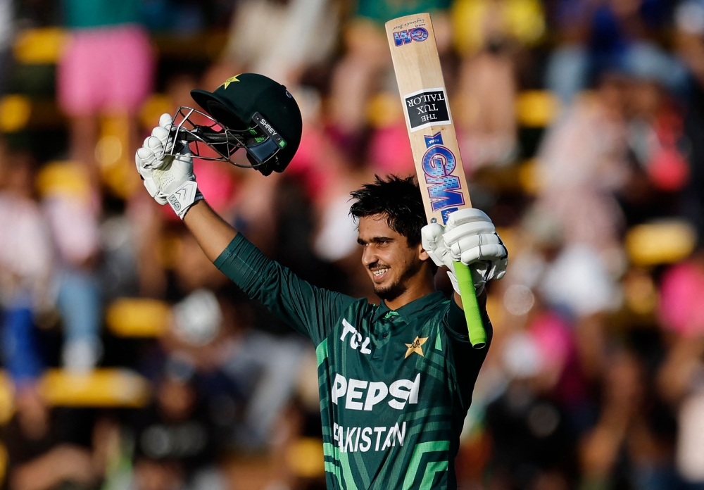 Pakistan's Saim Ayub celebrates after scoring a century (100 runs) during the third one day international (ODI) cricket match batween South Africa and Pakistan at The Wanderers Stadium in Johannesburg on December 22, 2024. (Photo by Phill Magakoe / AFP)