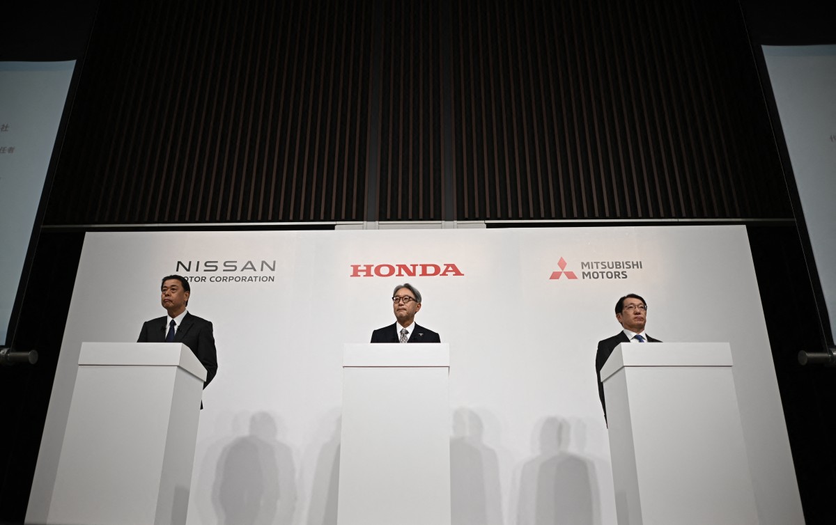 (L to R) Makoto Uchida, President and CEO of Nissan motor corporation, Toshihiro Mibe, President and Representative Executive Officer of Honda, and Takao Kato, President and CEO of Mitsubishi Motors attend a joint press conference in Tokyo on December 23, 2024. Photo by Philip FONG / AFP.
