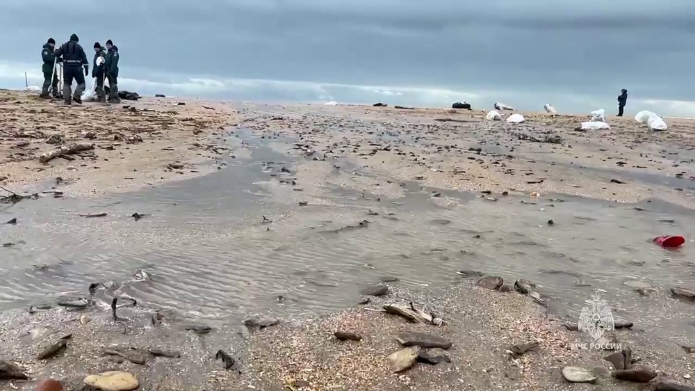 In this grab taken from a handout footage released by the Russian Emergencies Ministry on December 17, 2024, rescuers respond to an oil spill along the coastline of the Black Sea, caused by the wreck of two oil tankers, with the one which broke apart, in a storm in the Kerch Strait between Crimea and southern Russia's Krasnodar region on December 15. (Photo by Handout / Russian Emergencies Ministry / AFP)