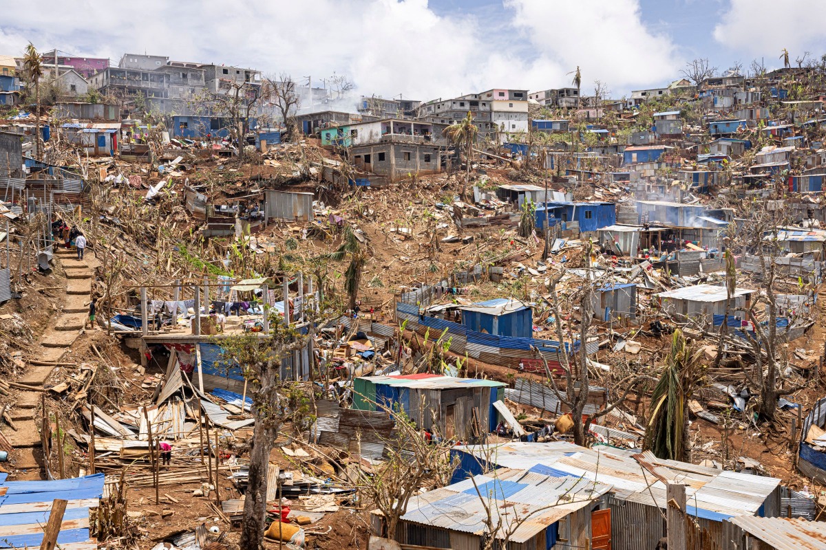 This photograph shows a general view of damaged shelters and houses in the town of Vahibe, on the outskirts of Mamoudzou, on the French Indian Ocean territory of Mayotte, on December 24, 2024, a week after the cyclone Chido's passage over the archipelago. (Photo by PATRICK MEINHARDT / AFP)
