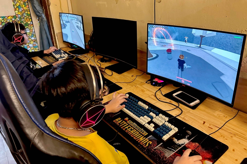 Youths play video games in a gaming room in Hanoi on December 25, 2024. (Photo by Nhac Nguyen / AFP)
 