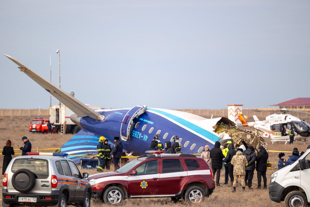 Emergency specialists work at the crash site of an Azerbaijan Airlines passenger jet near the western Kazakh city of Aktau on December 25, 2024. (Photo by Issa Tazhenbayev / AFP)
 