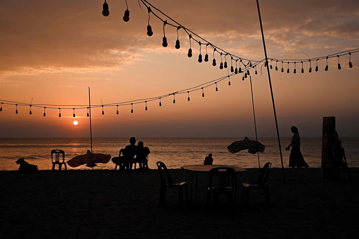 People walk along the beach nearby the Ban Nam Khem Tsunami Memorial Park in southern Thai province of Phang Nga on December 26, 2024. Photo by Lillian SUWANRUMPHA / AFP