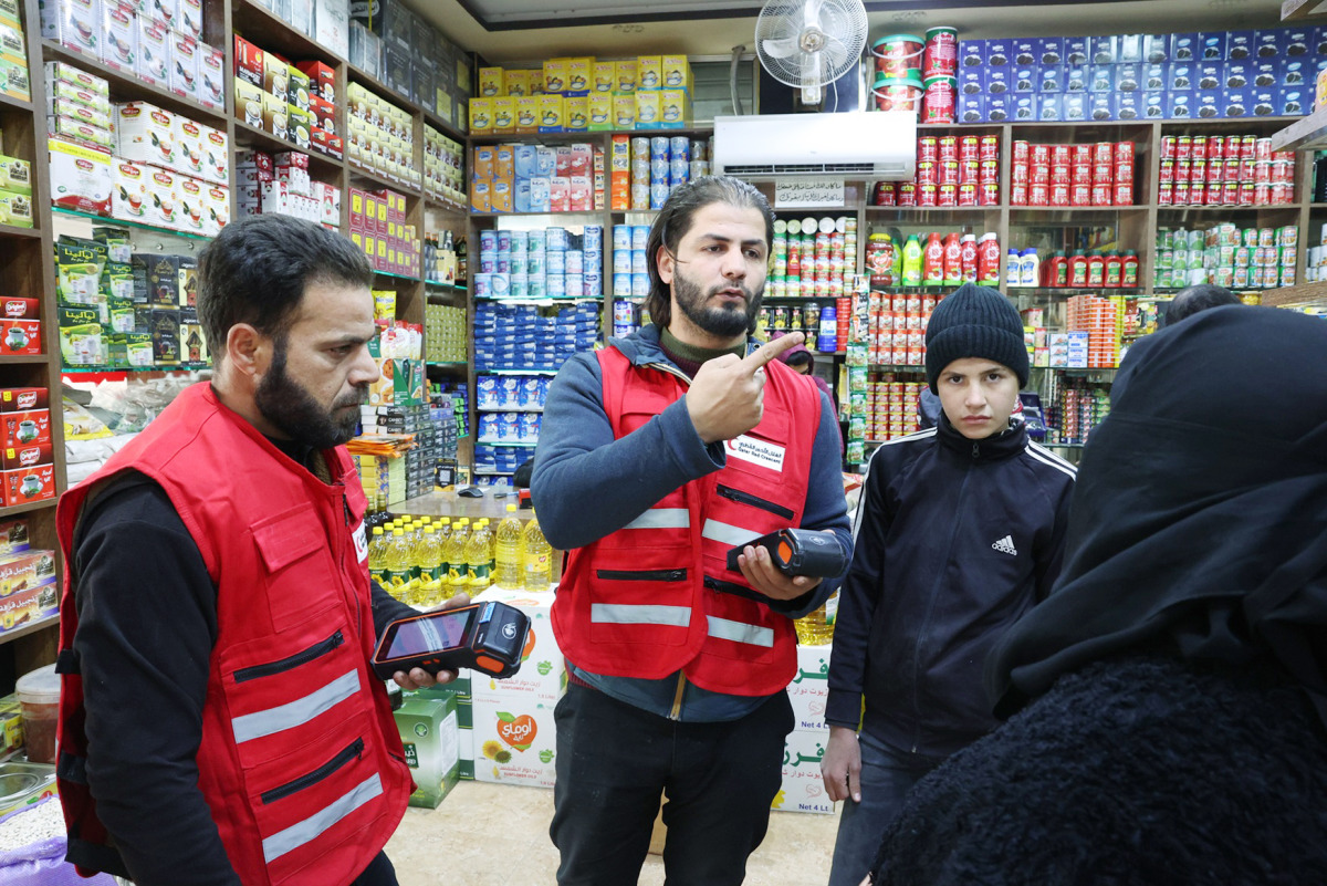 QRCS volunteers talking to a beneficiary.