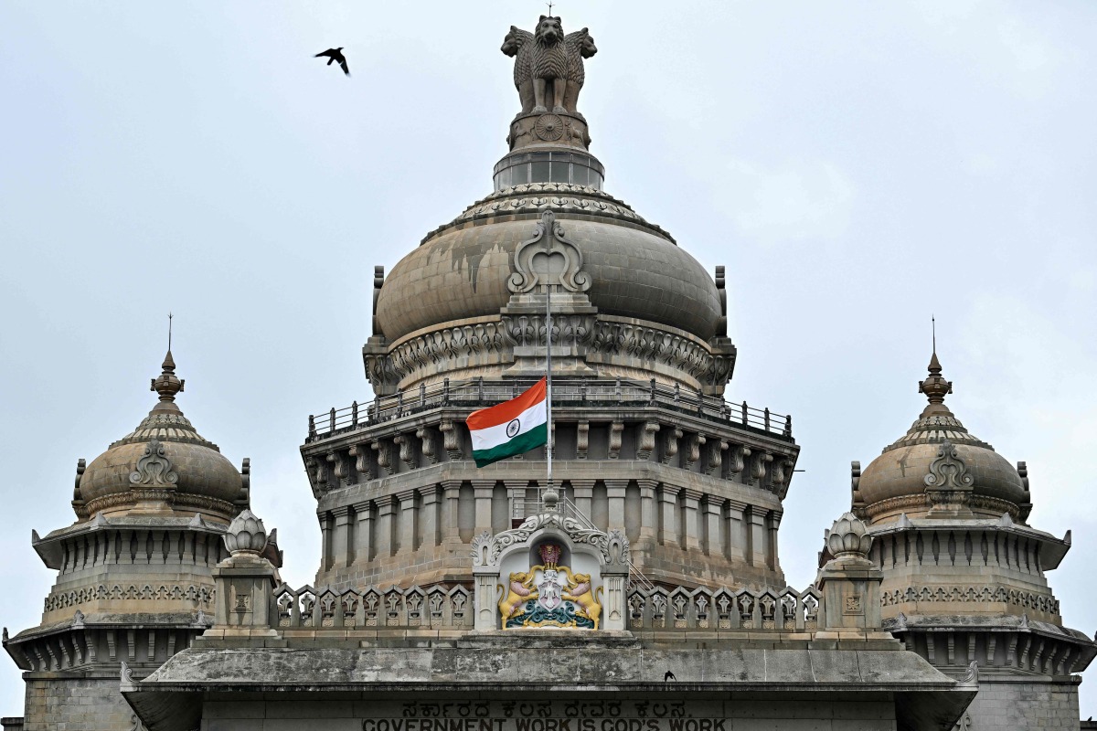 The Indian national flag flies half-mast at the Vidhana Soudha to mourn the death of former Indian Prime Minister Manmohan Singh, in Bengaluru on December 27, 2024. 