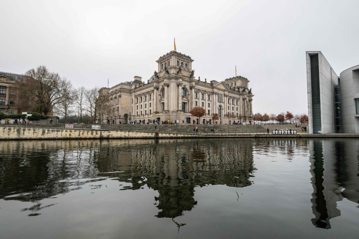 The Reichstag building, which houses Germany's lower house of parliament (Bundestag) is reflected in the river Spree in Berlin on December 27, 2024. Photo by John MACDOUGALL / AFP