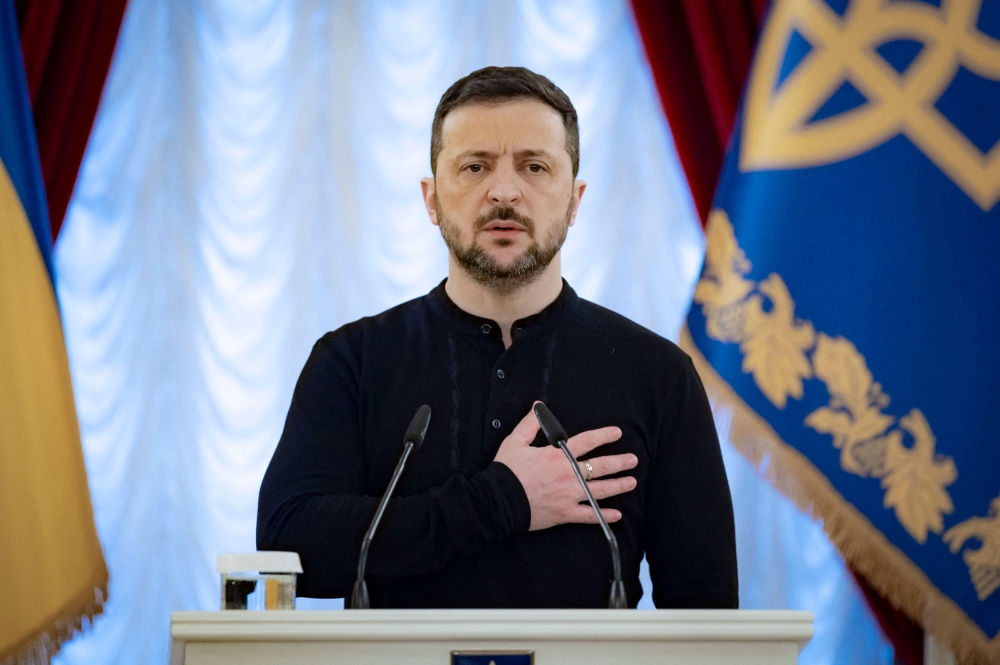 This handout picture taken and released by Ukrainian Presidential Press Service on December 26, 2024 shows Ukrainian President Volodymyr Zelensky stands for the National anthem of Ukraine during an award ceremony in Kyiv. (Photo by Handout / Ukrainian Presidential Press Service / AFP)