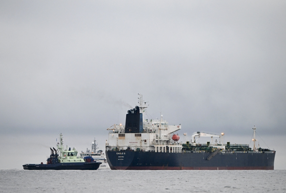 A photo taken on December 28, 2024 off Porkkalanniemi, Kirkkonummi, in the Gulf of Finland, shows oil tanker Eagle S (R), which flies under the flag of the Cook Islands, next to Finnish border guard ship Uisko (back C) and tugboat Ukko (front L). (Photo by Jussi Nukari / Lehtikuva / AFP)