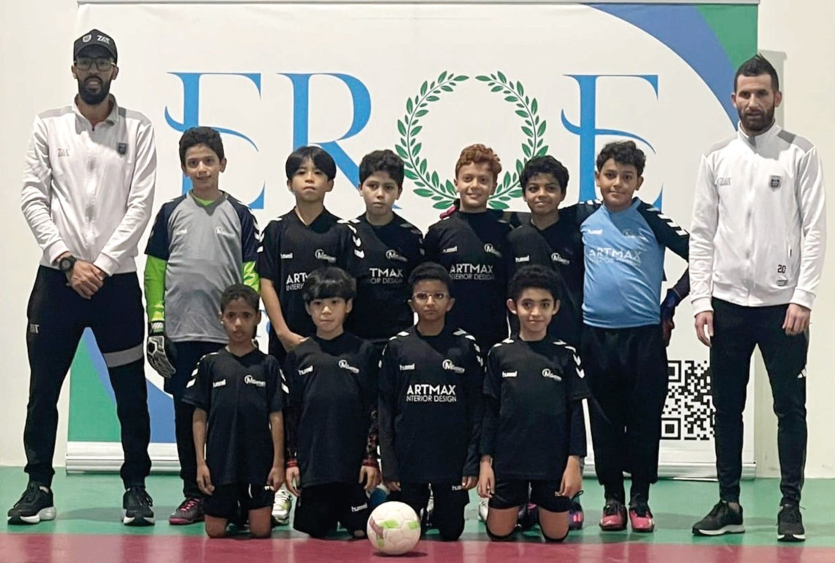 The victorious Msheireb Academy players and officials pose for a photograph.