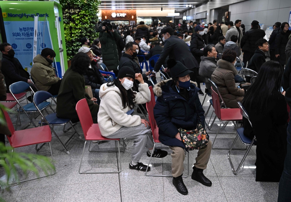 People and relatives of passengers of the crashed Jeju Air Boeing react at Muan International Airport in South Jeolla Province on December 29, 2024. (Photo by Jung Yeon-Je / AFP)