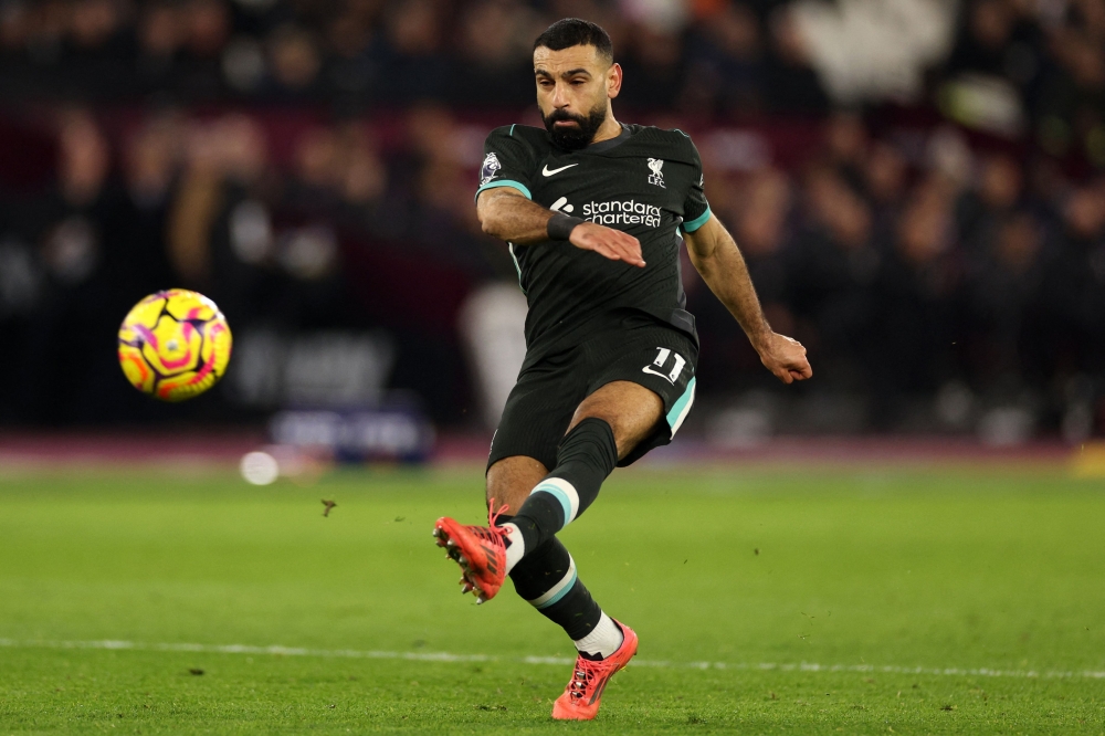 Liverpool's Egyptian striker #11 Mohamed Salah shoots but fails to score during the English Premier League football match between West Ham United and Liverpool at the London Stadium, in London on December 29, 2024. (Photo by Adrian Dennis / AFP)